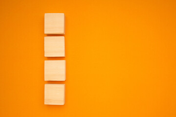 Top view of blank four wooden cubes on a yellow background with space for text