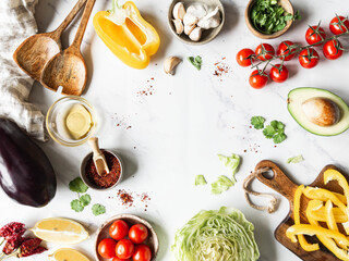 Flat lay cooking at home concept with fresh healthy vegetables chopped, salads and kitchen wooden utensils.