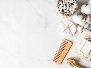 Zero waste personal bathroom accessories. Wooden brush, soap, toothbrush, cotton towel on marble background.