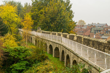 Fototapeta premium Arches under the trail on top of medieval 13th century city wall with view of the town of York in England