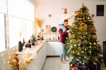 A loving happy young couple enjoying time together near Christmas tree. Romantic day. Winter holidays.