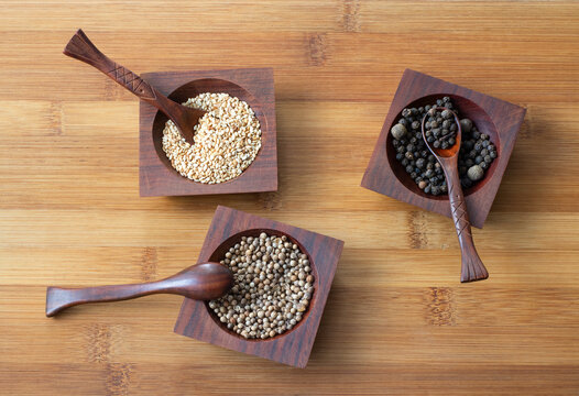 Spices for cooking, black and white peppers, sesame seeds.