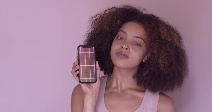 Young adult female using smartphone technology to colour match skin tone for cosmetics