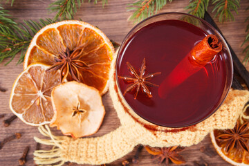 Glass of mulled wine wrapped scarf, spices and spruce branches