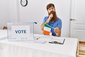 Caucasian man with long beard at political campaign election holding ireland flag serious face...