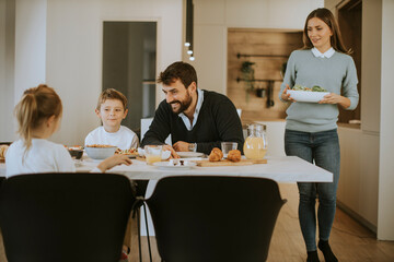 Young mother preparing breakfast for her family in the kitchen