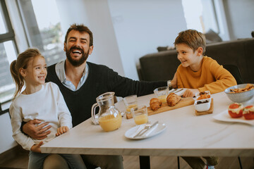 Father having breakfast with his son and daughter at home