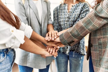Group of young businesswoman standing with hands together at the office.