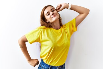 Young brunette woman standing over isolated background stretching back, tired and relaxed, sleepy and yawning for early morning