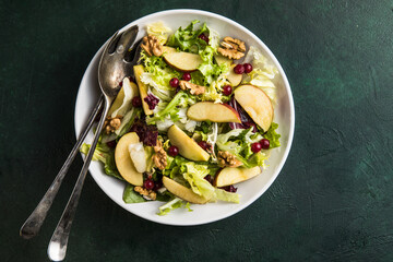 Fresh Waldorf salad with lettuce, green apples, walnuts and celery on wooden table. Top view.Copy space