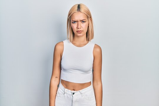 Beautiful blonde woman wearing casual style with sleeveless shirt skeptic and nervous, frowning upset because of problem. negative person.