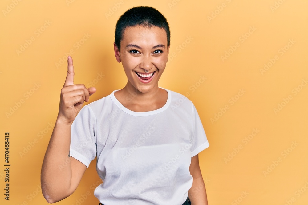 Poster Beautiful hispanic woman with short hair wearing casual white t shirt pointing finger up with successful idea. exited and happy. number one.