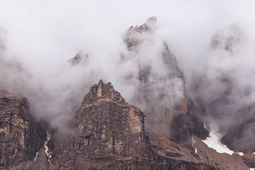 Peaks of the Italian Dolomites surrounded by low clouds after rain