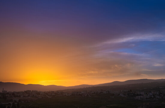 Colorful sunset sky over the city with hills. Jarash Jordan,