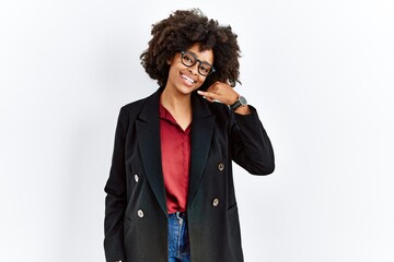 African american woman with afro hair wearing business jacket and glasses smiling doing phone gesture with hand and fingers like talking on the telephone. communicating concepts.