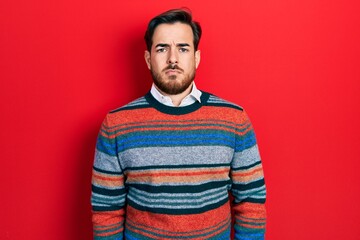 Fototapeta premium Handsome caucasian man with beard wearing elegant wool winter sweater depressed and worry for distress, crying angry and afraid. sad expression.