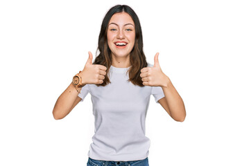 Young beautiful woman wearing casual white t shirt success sign doing positive gesture with hand, thumbs up smiling and happy. cheerful expression and winner gesture.