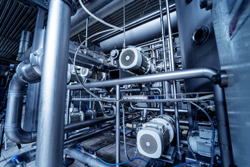 Modern interior of a beverage plant with barrels and pipes