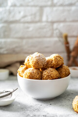 Homemade coconut cookies in a white plate on a light gray culinary background