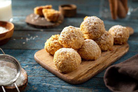 Homemade coconut cookies on a serving board on a blue wooden culinary background