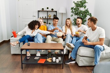 Group of young friends smiling happy watching movie at home.