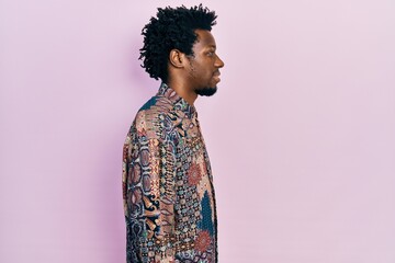 Young african american man wearing casual clothes looking to side, relax profile pose with natural face with confident smile.