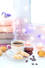 Christmas mood, a cup of coffee with sweets on a winter window under burning candles