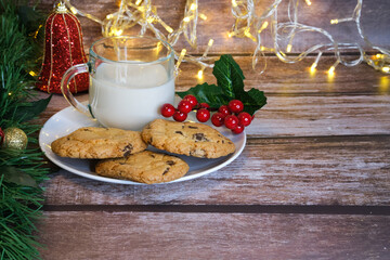 Milk with Christmas cookies for santa claus on a wooden table, selective focus