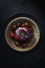 Blue and cherry raf tomatoes with dark background 