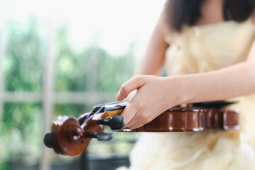 Musician woman inspects a violin before a concert. Close-up of the hand that is putting the instrument together