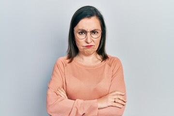 Middle age hispanic woman wearing casual clothes and glasses skeptic and nervous, disapproving...