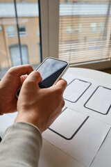Designer is developing a UX mobile application wireframe. Sketch, prototype, framework, layout future app design for smartphone. UI/UX - user interface and user experience designer. App development