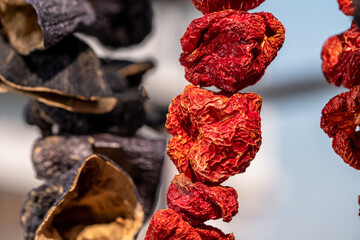 Dry eggplant and dry bell chili hanging in the market, local ingredient, closeup selective focus on blurred background.