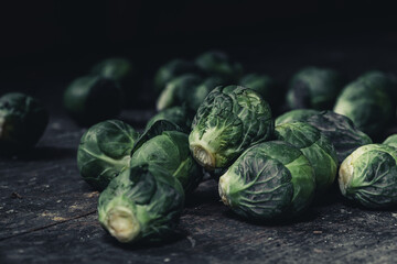 Brussels sprouts cabbage on old wooden table.Dark mood food photography.