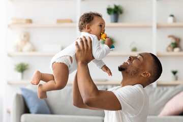 Father Baby Relationship. Happy Black Man Lifting Up His Adorable Infant Son