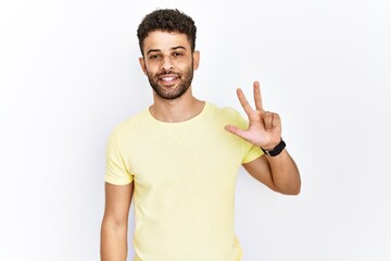 Arab young man standing over isolated background showing and pointing up with fingers number two while smiling confident and happy.