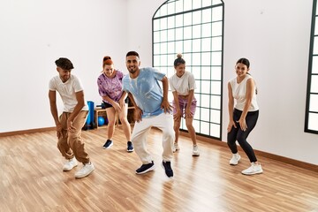 Group of young dancer smiling happy dancing choreography at dance academy.