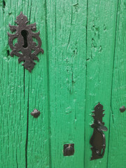 Detalle cerradura en puerta de madera antigua pintada de verde