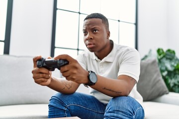 Young african man playing video games at home