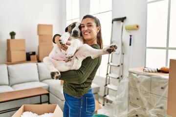 Young woman smiling confident hugging dog at home