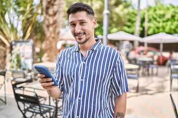 Young handsome man using smartphone at park