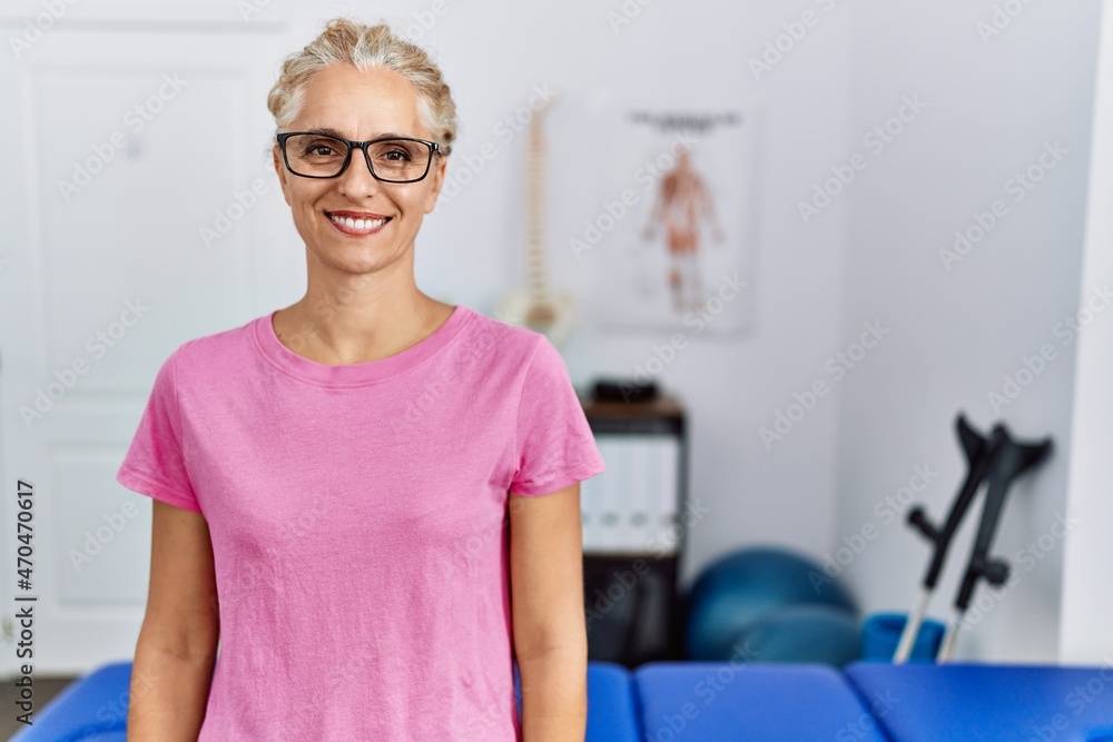 Poster middle age blonde woman at pain recovery clinic with a happy and cool smile on face. lucky person.