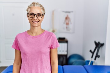 Middle age blonde woman at pain recovery clinic with a happy and cool smile on face. lucky person.