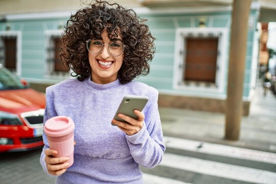 Young middle east woman smiling confident using smartphone at street