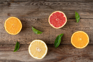Fototapeta na wymiar Citruses on a wooden background. Cut fruit. Juicy grapefruit and orange. View from above
