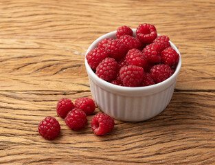 Raspberries in a bowl over wooden table