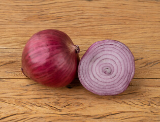 Purple or red onion and a half over wooden table