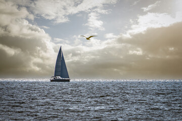 a sailboat on the ocean sailing on a stormy day