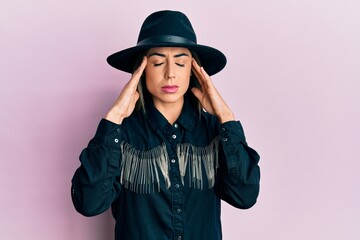 Young hispanic woman wearing cowgirl style suffering from headache desperate and stressed because pain and migraine. hands on head.
