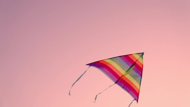 kite on a pink sky background, children's toy flying high, rainbow game flying a kite in the wind, happy vacation, enjoy nature